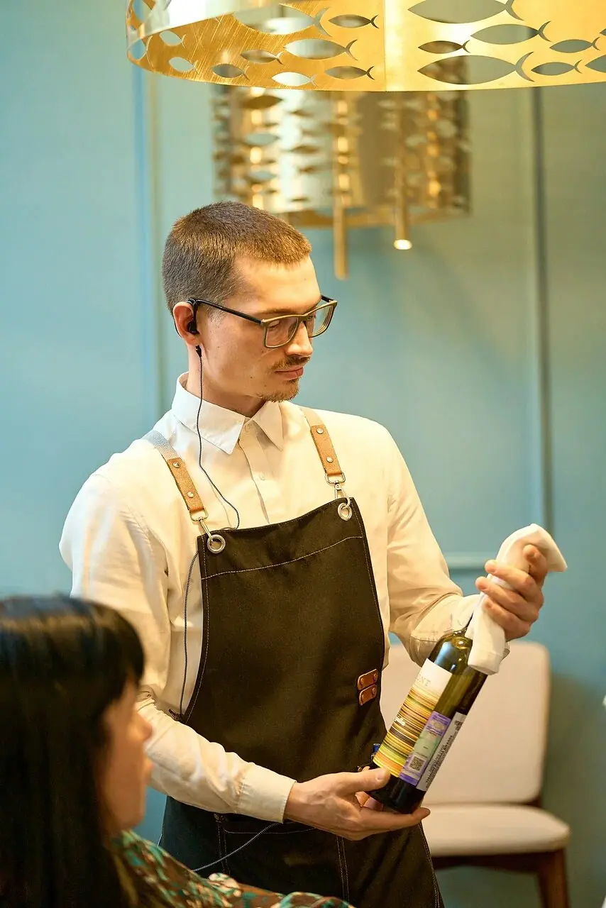 A server presents a bottle of wine at the table